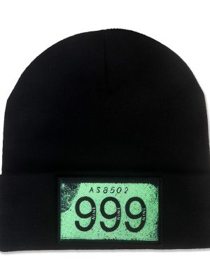 Black knitted beanie hat with folded cuff and rectangular distressed green patch displaying the black 999 punk rock band logo.