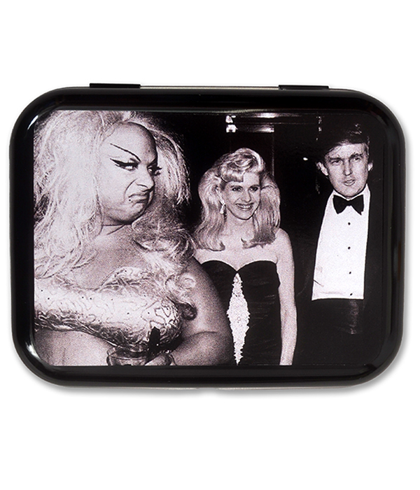 Glossy black metal tin featuring a black and white photo of Divine, a blonde woman and Donald Trump on the lid.