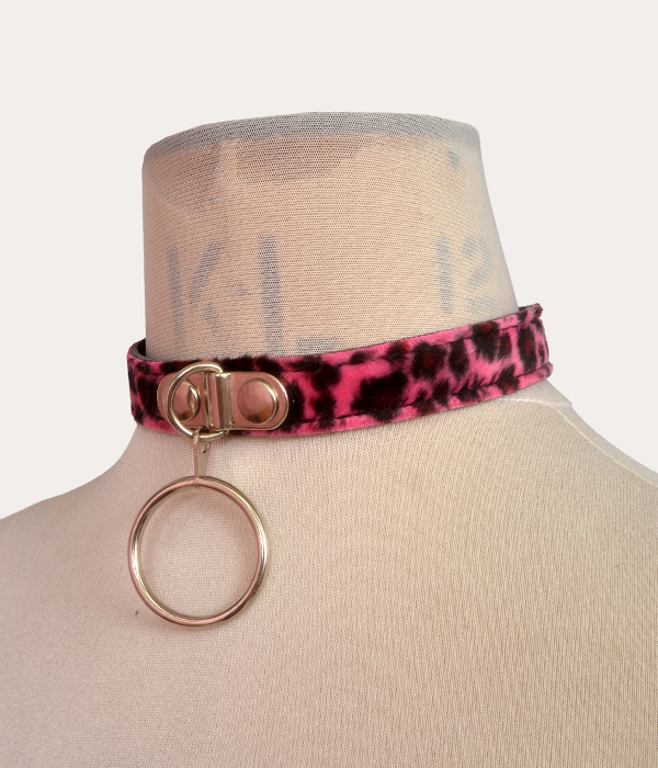 Hot pink and black leopard print adjustable punk collar on a mannequin, with silver-tone front O-ring detail and buckle fastening.