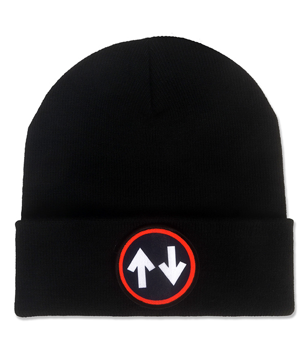 Black knitted mod beanie hat with folded cuff and circular black patch featuring two opposing white arrows surrounded by a bright red border.