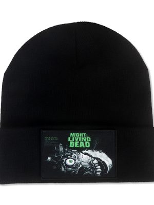 Black knitted Night of the Living Dead beanie hat with folded cuff and rectangular zombie horror patch featuring a grotesque face, exposed eyeball and green lettering.