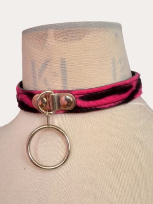 Pink and black zebra print adjustable punk collar on a mannequin, with silver-tone front O-ring detail and buckle fastening.
