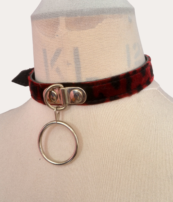 Red and black leopard print adjustable punk collar on a mannequin, with silver-tone buckle fastening and large front O-ring detail.