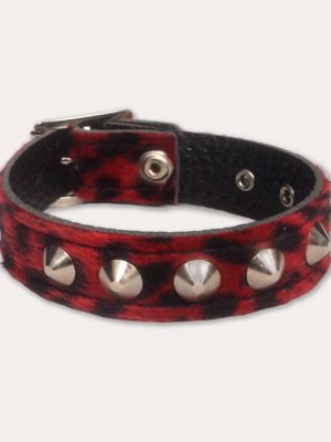 Front image: Red and black leopard print punk wrist cuff with silver-tone cone studs, black inner lining and adjustable metal fastening.