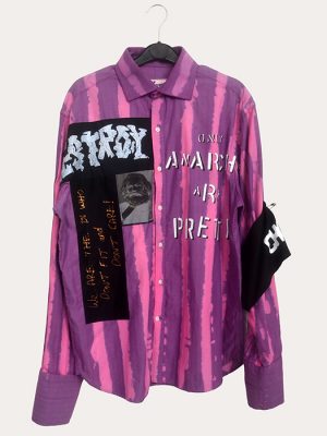 Men’s Seditionaries reproduction punk shirt with distressed purple and pink stripes and slogan graphics hanging on a rail