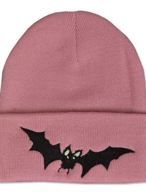 Dusty pink knitted beanie hat with wide folded cuff featuring a black embroidered vampire bat with outstretched pointed wings and pale green eyes.