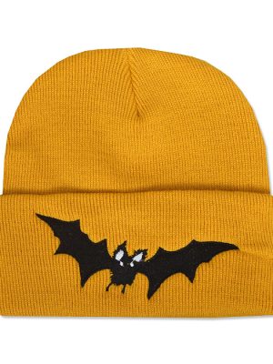 Mustard yellow knitted beanie hat with wide folded cuff featuring a black embroidered vampire bat with outstretched wings and small white facial details.