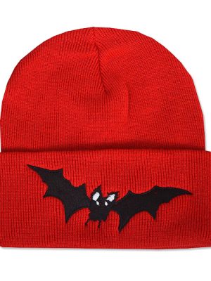 Bright red knitted beanie hat with wide folded cuff featuring a black embroidered vampire bat with outstretched pointed wings and small white eyes.