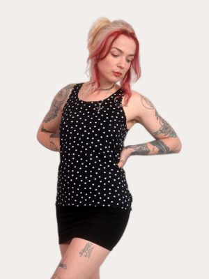 Woman wearing a black star print tank top, sleeveless punk vest, alternative women’s clothing, made in the UK.